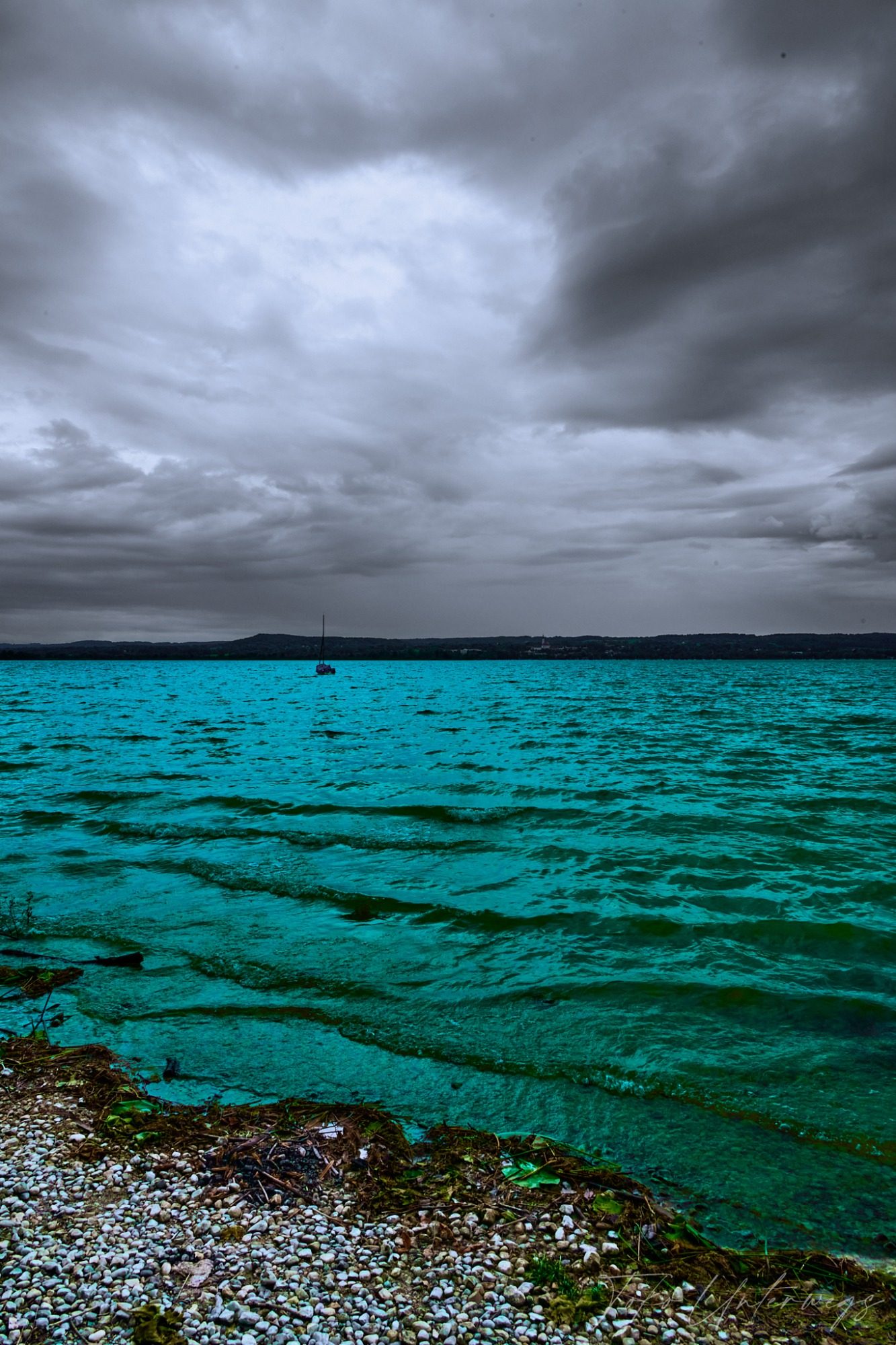 Graues Himmel über einem turquoise Wasser mit sanften Wellen.